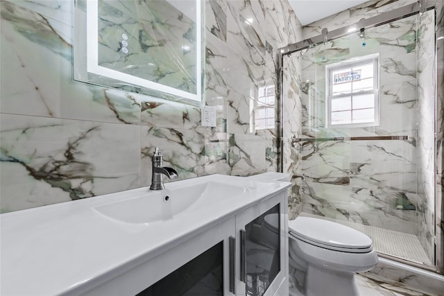 bathroom featuring stone wall, toilet, vanity, marble finish floor, and a marble finish shower