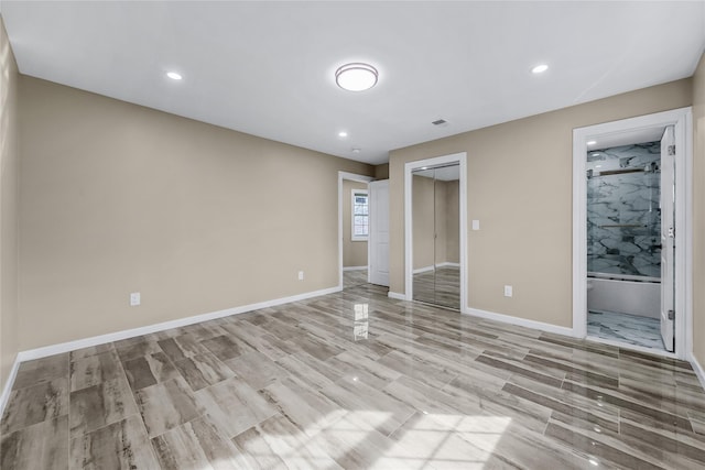 unfurnished bedroom featuring a closet, recessed lighting, light wood-style flooring, and baseboards