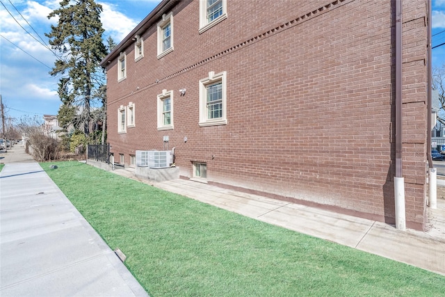 view of side of property with a yard and brick siding