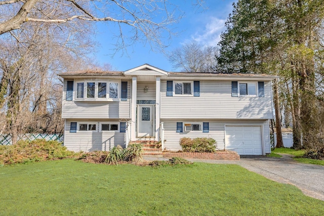 split foyer home featuring an attached garage, driveway, and a front lawn