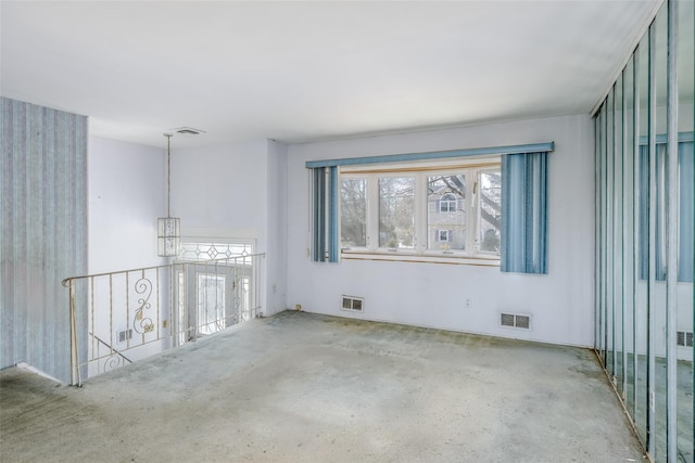 spare room with a wealth of natural light and visible vents