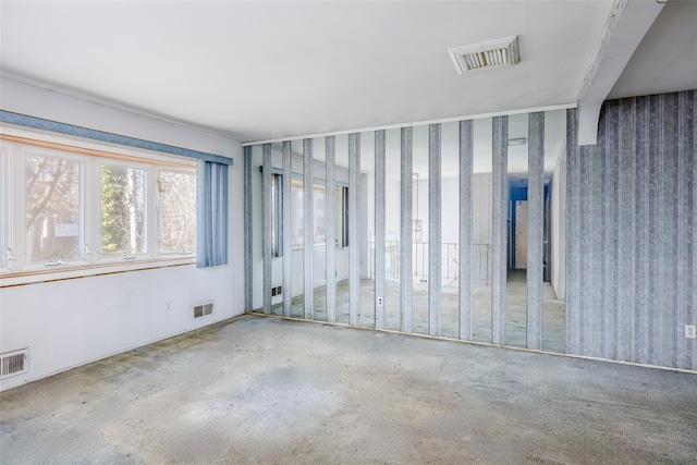 spare room featuring visible vents and wallpapered walls