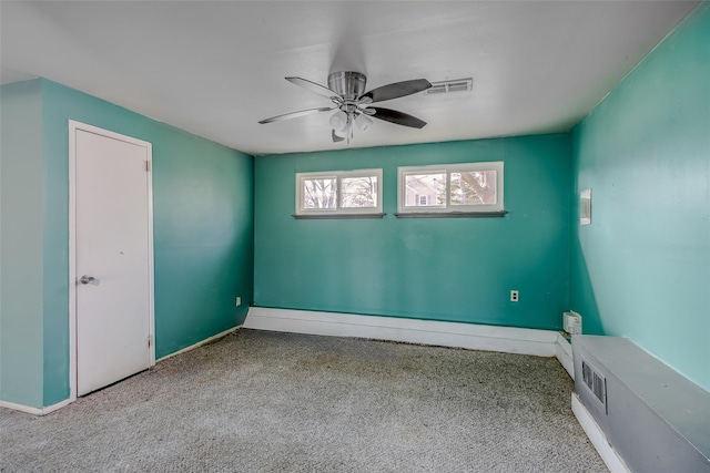 unfurnished room with a ceiling fan, visible vents, and baseboards