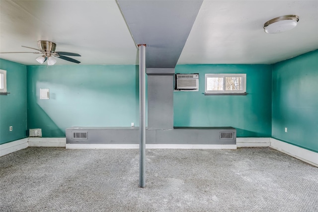 carpeted empty room featuring a wall unit AC, ceiling fan, visible vents, and baseboards