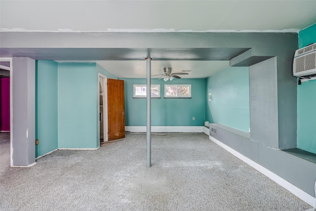 basement with baseboards, a wall mounted AC, visible vents, and a ceiling fan