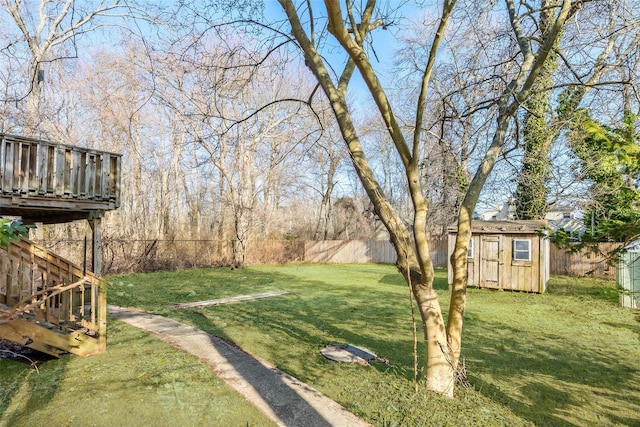 view of yard with a storage shed, a fenced backyard, and an outbuilding