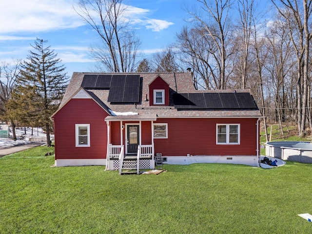 rear view of house featuring a shingled roof, crawl space, a yard, and solar panels