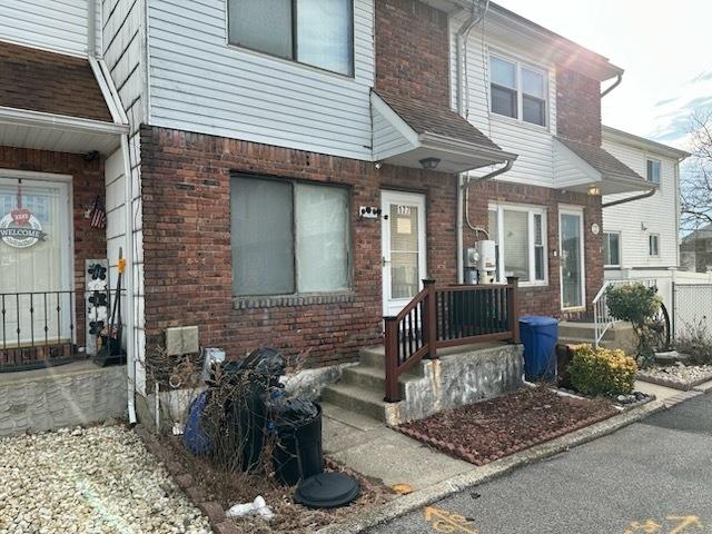 doorway to property featuring brick siding