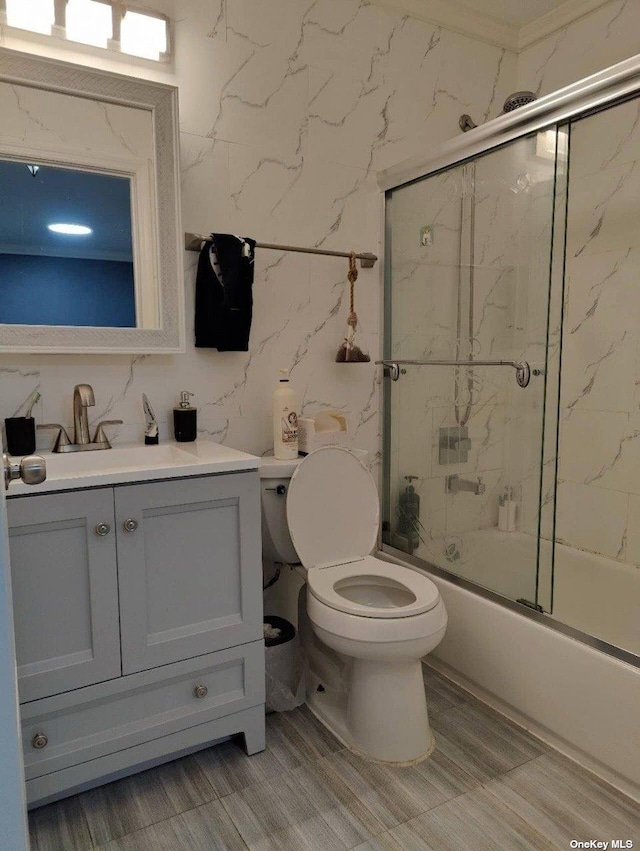 full bathroom featuring toilet, combined bath / shower with glass door, and vanity