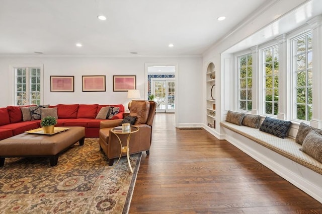 living area featuring hardwood / wood-style floors, built in shelves, recessed lighting, and baseboards