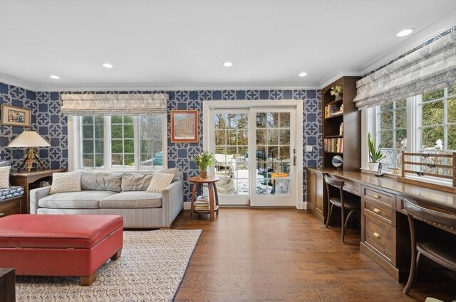 interior space with dark wood-style floors, built in study area, wallpapered walls, recessed lighting, and ornamental molding