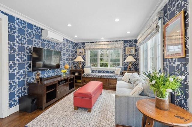 living room featuring an AC wall unit, wood finished floors, crown molding, and wallpapered walls