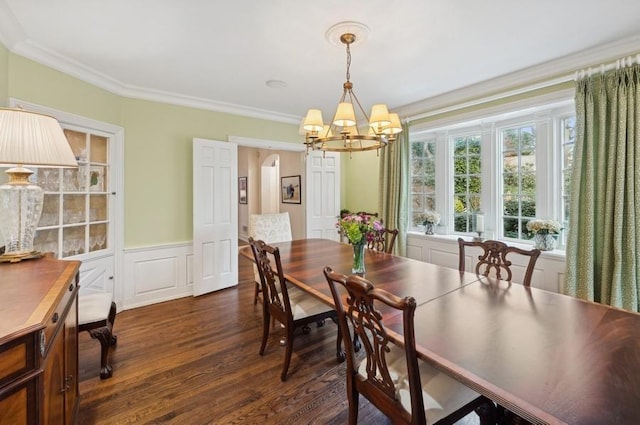 dining area with an inviting chandelier, arched walkways, ornamental molding, dark wood-type flooring, and wainscoting