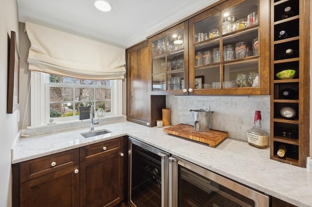 bar featuring wine cooler, backsplash, bar area, and a sink