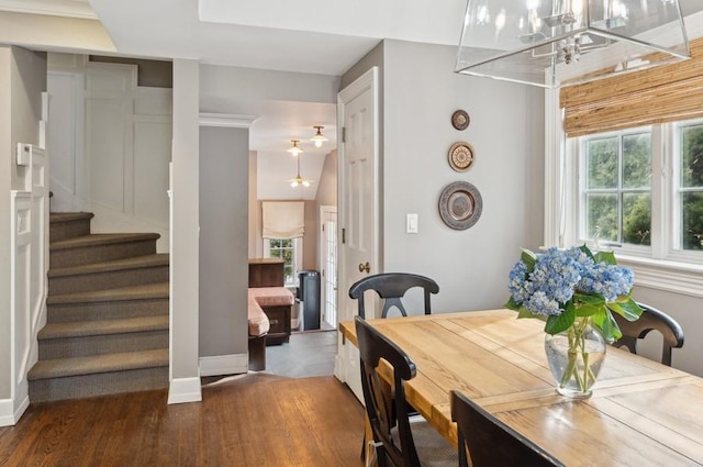 dining area with an inviting chandelier, stairs, baseboards, and wood finished floors