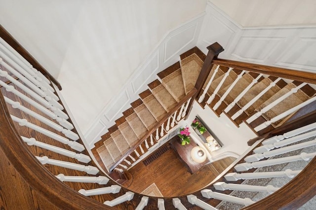 stairway featuring a decorative wall and a wainscoted wall