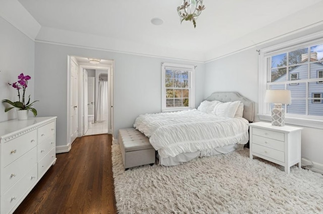 bedroom with multiple windows, baseboards, and dark wood-style flooring