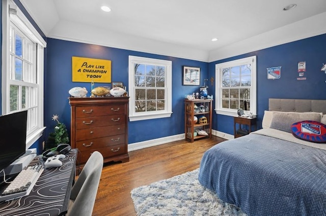 bedroom with baseboards, multiple windows, and wood finished floors