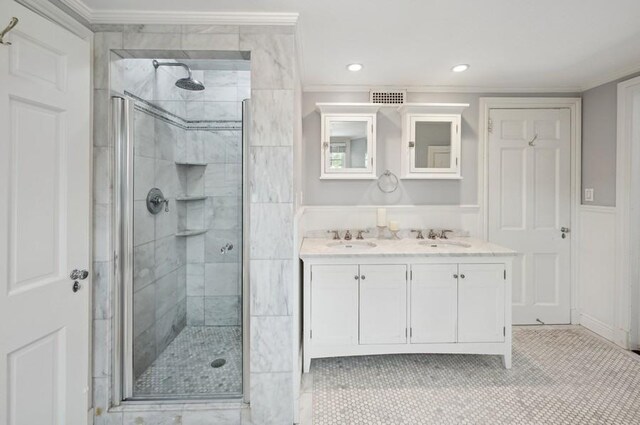 full bath featuring a shower stall, crown molding, and a sink