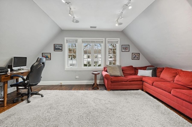 office area featuring dark wood finished floors, visible vents, baseboards, and vaulted ceiling