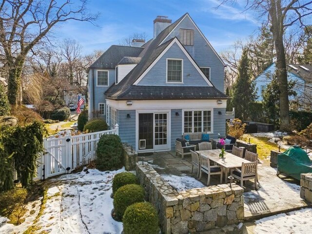 rear view of house featuring an outdoor living space, a chimney, a patio, and a gate