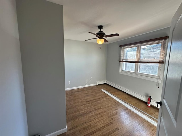 empty room with ceiling fan, baseboard heating, baseboards, and dark wood finished floors