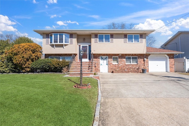 raised ranch with an attached garage, a front lawn, concrete driveway, and brick siding