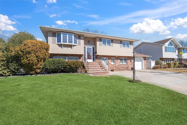 bi-level home with a garage, driveway, brick siding, and a front lawn