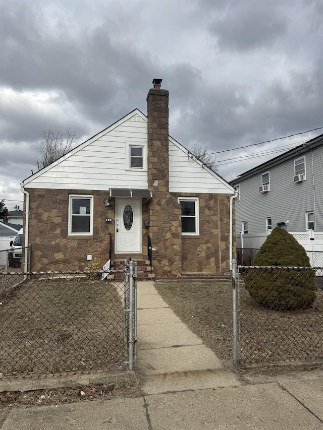 bungalow-style house with a fenced front yard, stone siding, and a chimney