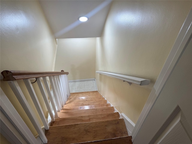 staircase with recessed lighting, vaulted ceiling, baseboards, and wood finished floors