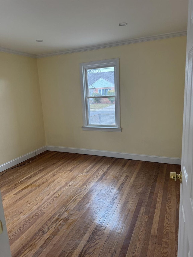 unfurnished room featuring baseboards, dark wood finished floors, and crown molding