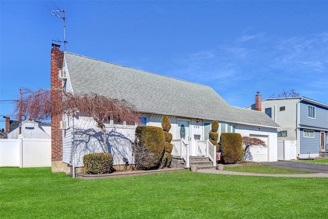 view of front of house with an attached garage, a shingled roof, fence, a front lawn, and a chimney