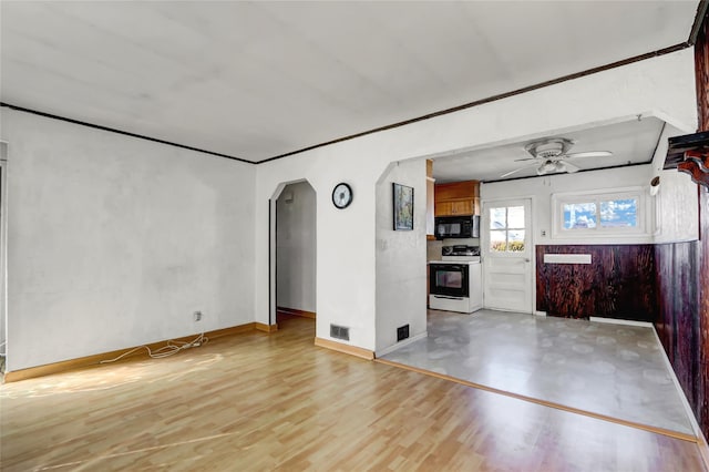 unfurnished living room with visible vents, arched walkways, baseboards, ceiling fan, and light wood-style flooring