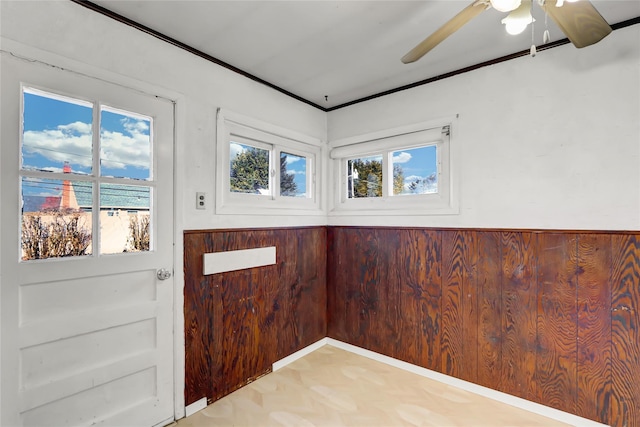 entryway with a ceiling fan and crown molding