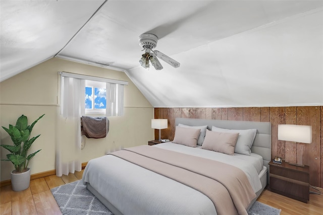 bedroom with vaulted ceiling, light wood finished floors, and a ceiling fan