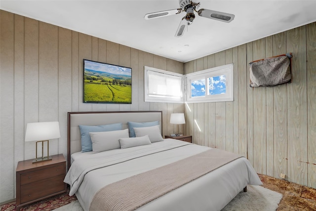 bedroom featuring wood walls and a ceiling fan