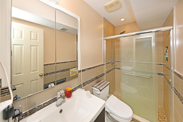 full bathroom featuring toilet, a shower stall, visible vents, and tile walls