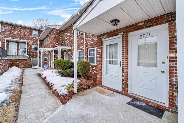 entrance to property featuring brick siding and a porch