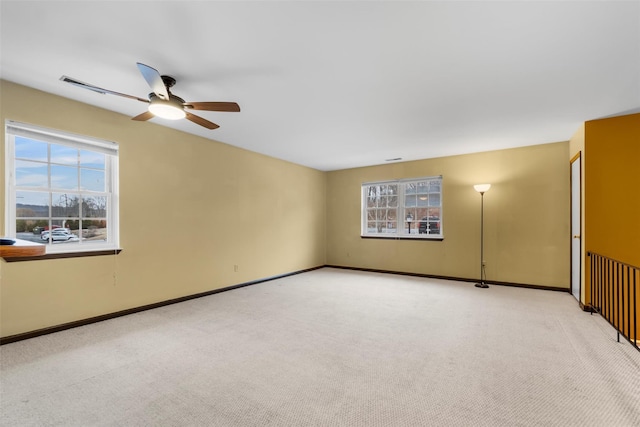 carpeted empty room with ceiling fan and baseboards