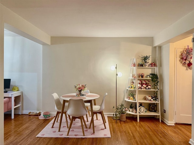 dining space with wood finished floors and baseboards