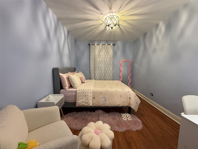 bedroom featuring baseboards and wood finished floors