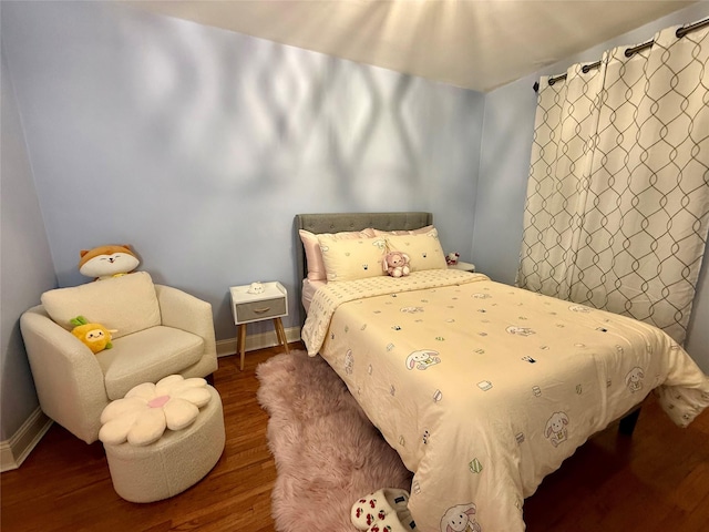 bedroom featuring wood finished floors and baseboards