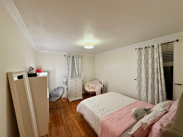 bedroom featuring wood finished floors and crown molding