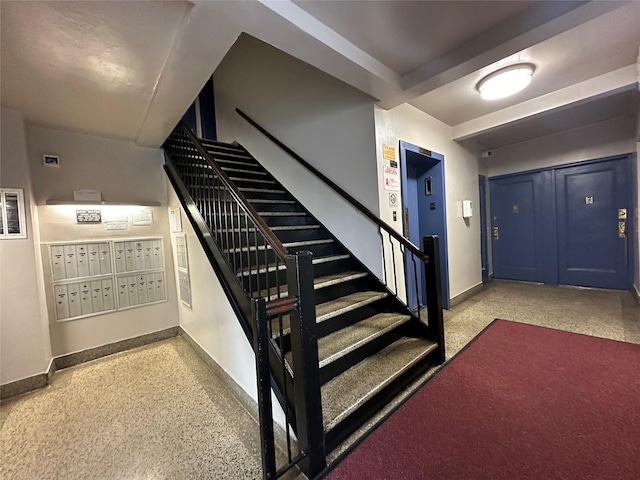 stairs with baseboards, mail area, and speckled floor