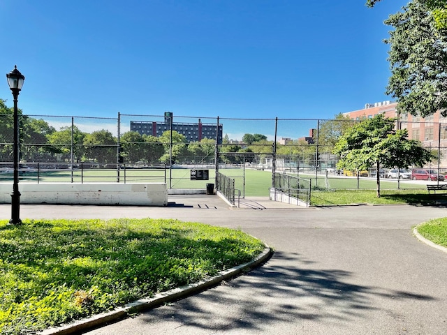 surrounding community with a tennis court and fence