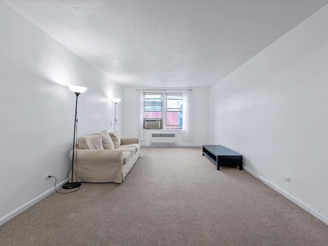 carpeted living area with baseboards, cooling unit, and radiator