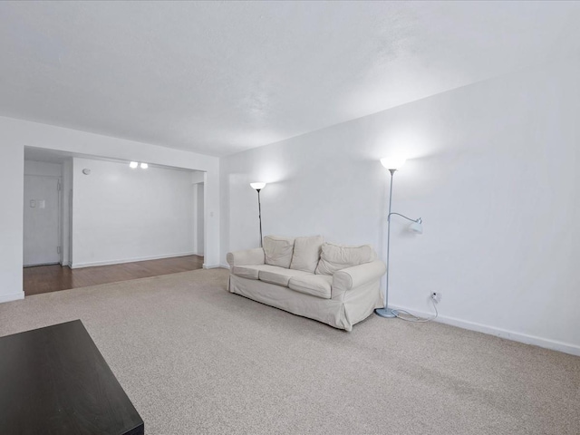 carpeted living room featuring baseboards