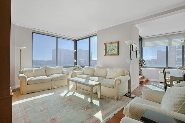 living area featuring baseboards, plenty of natural light, wood finished floors, and crown molding