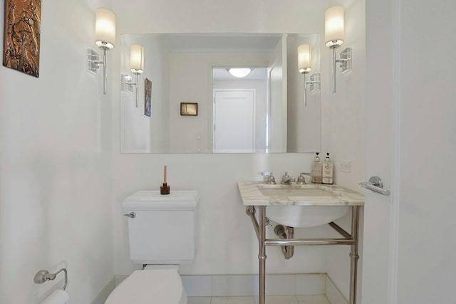 half bathroom with toilet and baseboards