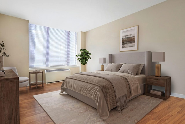 bedroom with radiator, baseboards, and light wood finished floors